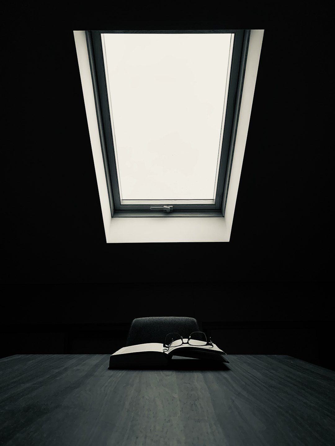 Reading glasses on an open book on a desk.