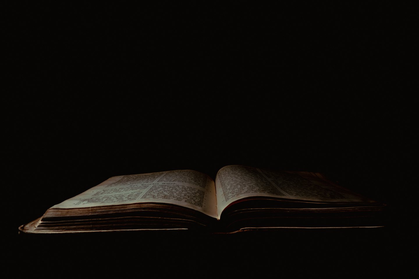 An open antique book with glowing weathered pages.